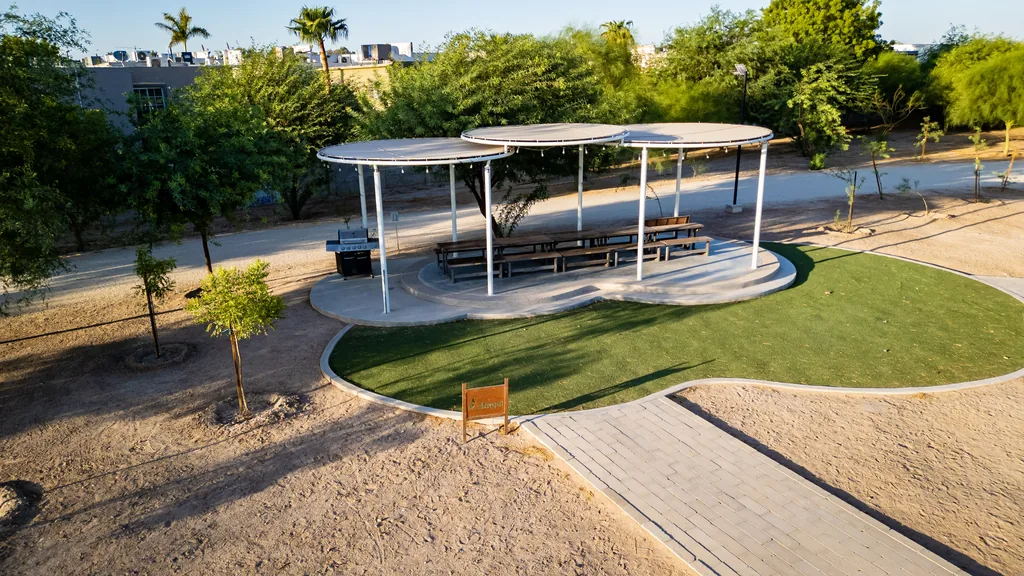 Palapa con mesas y asador sobre pasto en Tu Parque TSM